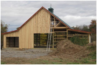 There's no law that says that a pole barn has to look like a box. Imagine this Walnut Barn when it is finished with a loft hatch and big barn doors. It's being built from inexpensive plans by architect Don Berg, available at BackroadHome.net